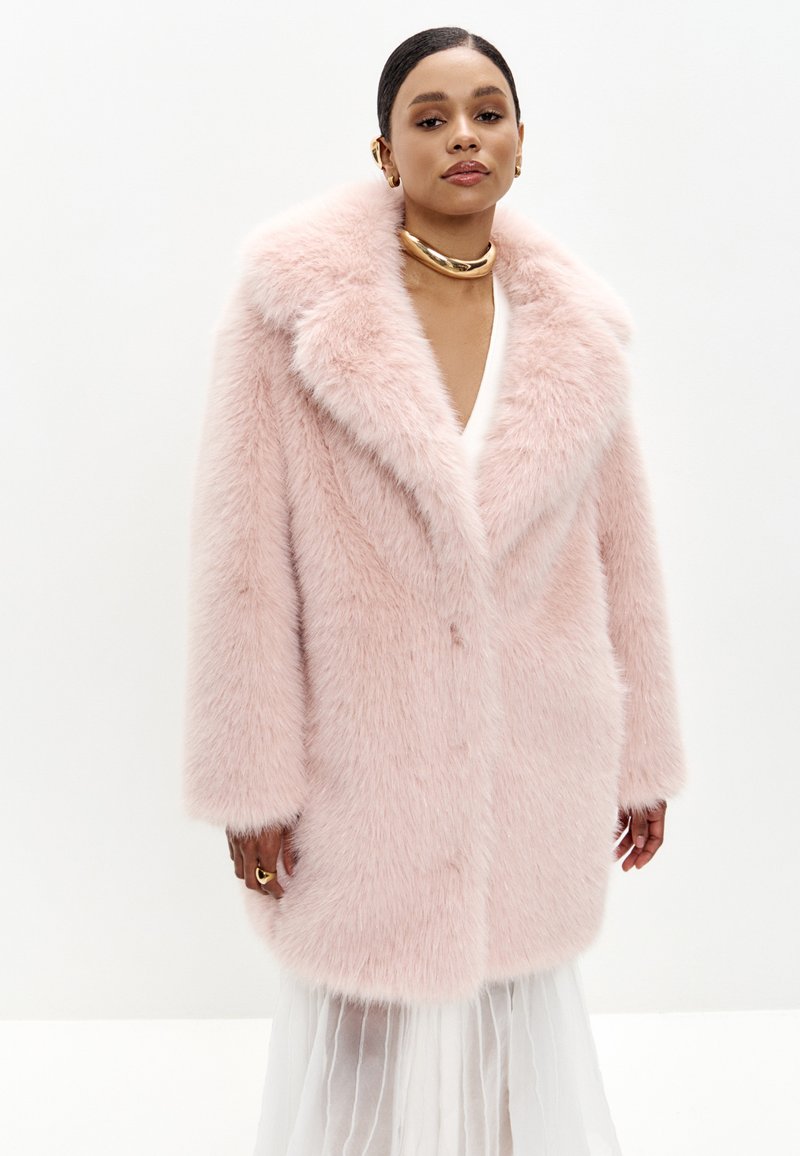 Lyserød faux fur frakke med bred krave, drop skuldre og lange ærmer, der har en blød tekstur og en enkelt knaplukning.