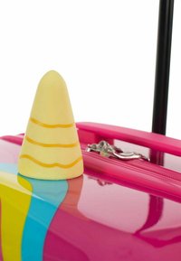 Una valigia rosa brillante con una finitura lucida presenta un cursore della zip a forma di cono giallo, accentuato da tre linee orizzontali arancioni.