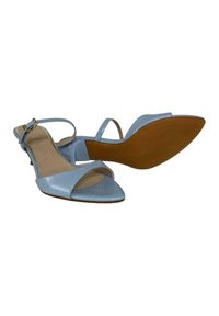 Sandali slingback blu chiaro a punta con una finitura lucida, sottile cinturino alla caviglia e un tacco basso e arrotondato. La suola presenta un motivo testurizzato.