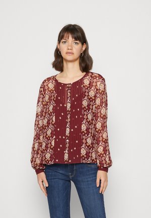 Blouse bordeaux en tissu léger et fluide avec motifs en transparent, dotée d'une fermeture à boutons, de poignets côtelés et d'une coupe décontractée.