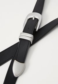 Ceinture en cuir noir avec boucle en métal argenté, un élément supplémentaire en métal argenté, texture lisse et design épuré.