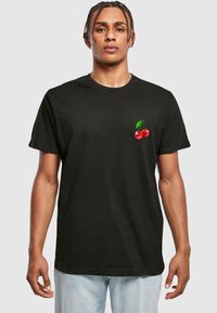 Sort bomulds t-shirt med et lille rødt kirsebærmotiv og grønne blade på venstre brystområde. Korte ærmer, normal pasform.