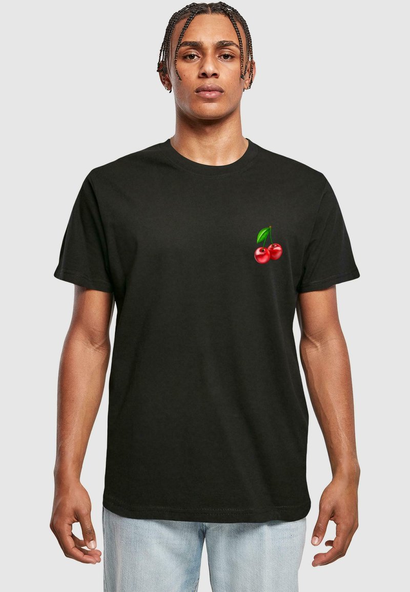 Sort bomulds t-shirt med et lille rødt kirsebærmotiv og grønne blade på venstre brystområde. Korte ærmer, normal pasform.