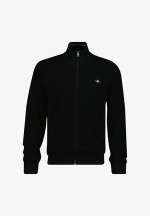 Giacca nera in maglia con zip, collo alto, texture a coste e dettaglio con logo sul petto sinistro. Presenta maniche lunghe e una vestibilità aderente.