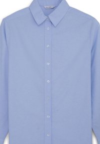 Chemise bleu clair à manches longues avec boutons, col pointu et petits boutons blancs au centre devant.