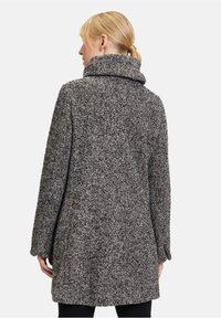 Grijs-zwart gestructureerd wollen jas met een hoge kraag en lange mouwen, met een ontspannen pasvorm en een lengte tot onder de knie.