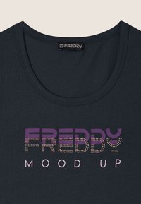 Top senza maniche di un blu scuro con scollatura a girocollo e il nome del marchio "FREDDY" in gradiente viola e rosa, impreziosito da strass.