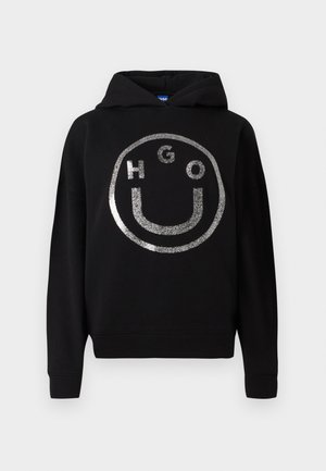 Μαύρη κουκούλα από μαλακό υλικό με σχέδιο μεγάλης ασημένιας γκλίτερ χαρούμενης φατσούλας και κείμενο "HGO" μέσα στον κύκλο.