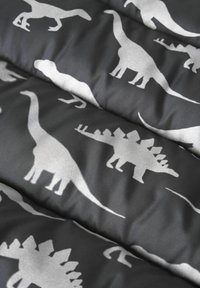 Schwarzer Stoff mit silbernen Dinosaurier-Silhouetten, darunter ein Brontosaurus und ein Stegosaurus, in einem sich wiederholenden Muster mit glatter Textur.
