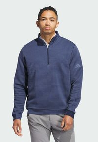 Marineblauer Pullover mit halbem Reißverschluss aus strukturiertem Stoff; verfügt über horizontale Streifen, gerippte Bündchen und ein dezentes Logo auf der linken Schulter.