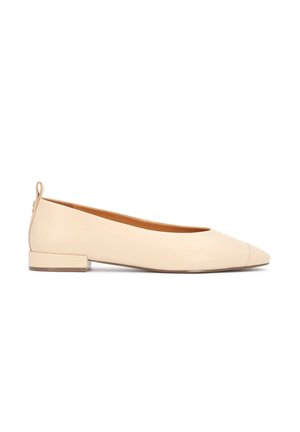 Beige spids tå lav hæl flad sko med trækflig bagpå, vist fra siden på hvid baggrund.