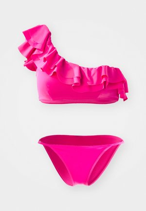 Μπικίνι τοπ με έναν ώμο σε ροζ χρώμα με βολάν λεπτομέρειες, συνδυασμένο με αντίστοιχα χαμηλής μέσης μπικίνι κάτω, και τα δύο κατασκευασμένα από απαλό και ελαστικό ύφασμα.