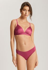 Doposito triangolare in raso rosa con dettagli in pizzo, spalline regolabili e bikini in coordinato rosa, caratterizzati da una superficie liscia e cuciture minime.
