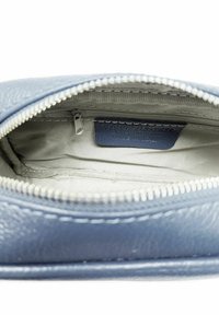 Pochette in pelle blu con chiusura a zip, caratterizzata da una superficie texturizzata e un rivestimento liscio. Un'etichetta interna nell'angolo identifica il marchio.