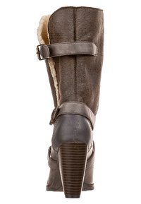 Botte en cuir marron avec un intérieur en fourrure, comprenant deux sangles réglables et un talon haut texturé. Détails en couture sur le corps.