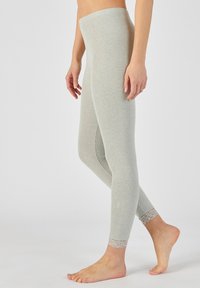 Lichtgrijze leggings van zachte stof. Beschikt over een gladde tailleband en kantdetails bij de enkels. Strak aansluitend ontwerp met een elegante uitstraling.