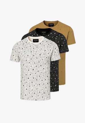 Tre t-shirts med rund hals: en vit med svarta vertikala mönster, en svart med liknande mönster och en senapsgul, alla kortärmade.