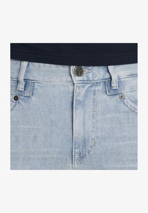 Jeans de mezclilla azul claro con un corte clásico, que cuentan con un cierre de botón con herrajes oscuros, cinco bolsillos y un sutil detalle de desgastado.