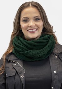 Dark green knitted infinity scarf with textured patterns, worn over a black top. A black jacket is also visible with silver hardware.
