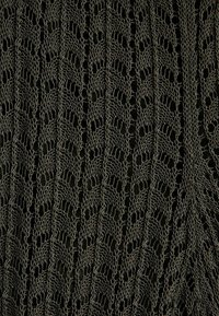 Tissu noir avec un motif de tricot en dentelle verticale présentant des motifs alternés de feuilles et des détails en ajouré.