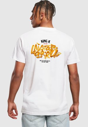 Hvid bomulds t-shirt med fed gul og sort tekst på ryggen, herunder "KING K" og et design i en legesyg stil.