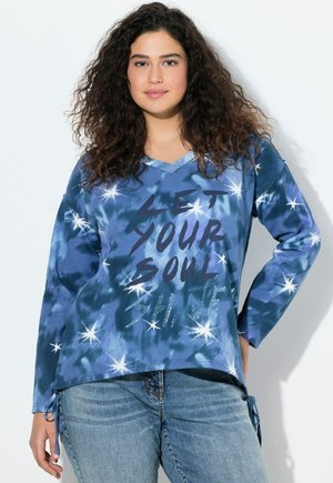 Felpa a maniche lunghe blu tie-dye con scollatura a V, che presenta il testo "LASCIATE CHE LA VOSTRA ANIMA BRILLI" e accenti di stelle, con lacci laterali regolabili.
