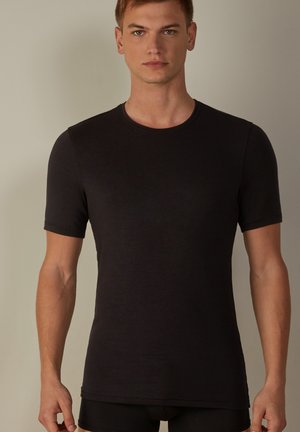Schwarzes kurzärmeliges T-Shirt aus einem weichen, leichten Stoff mit Rundhalsausschnitt, tailliertem Design und nahtloser Verarbeitung an den Ärmeln.