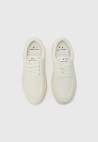 Weiße Sneaker mit glatter Oberfläche, runder Zehenform, Schnürdesign und dezentem Branding auf der Zunge. Helle Sohle.