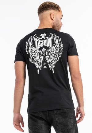 Tricou negru din bumbac, cu un grafic mare alb pe spate, reprezentând aripi de înger, cranii și textul "TAPOUT." Design cu decolteu rotund.