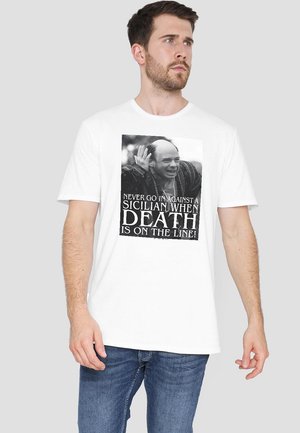 White cotton t-shirt featuring a black and white graphic print with text: "NEVER GO IN AGAINST A SICILIAN WHEN DEATH IS ON THE LINE!"
