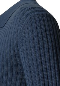 Marineblaues geripptes Polohemd mit einem strukturierten Design, kurzem Kragen und strukturiertem Stoff mit vertikalen Streifen, der eine figurbetonte Optik bietet.