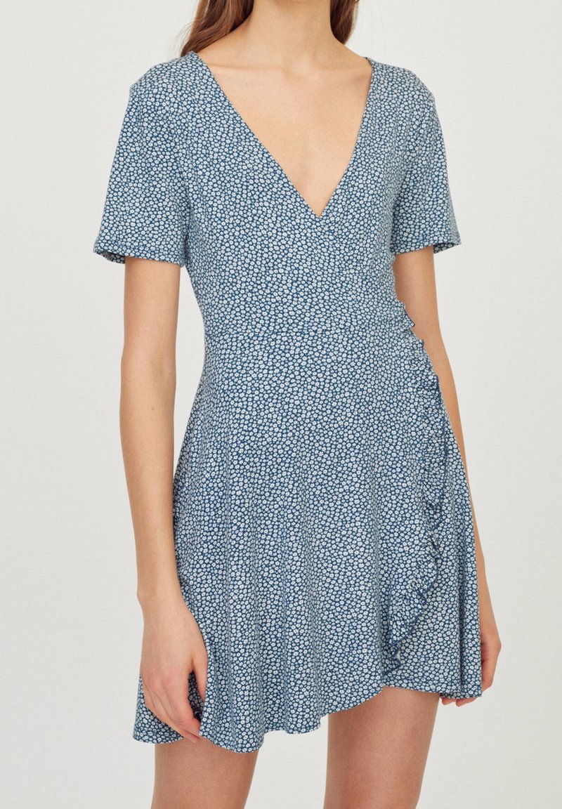 Modrá květinová zavinovací šaty s krátkým rukávem, výstřihem do V, s volánkovým detailem na boku, vyrobené z lehké látky, s rozptýleným malým bílým vzorem.