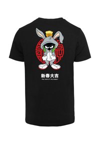 Black cotton t-shirt featuring a cartoon character with long ears, dressed in a grey hoodie, against a red circular design with text below.