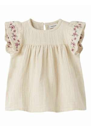 Robe de bébé couleur crème avec manches courtes à volants brodées de petites fleurs roses et de feuilles vertes.