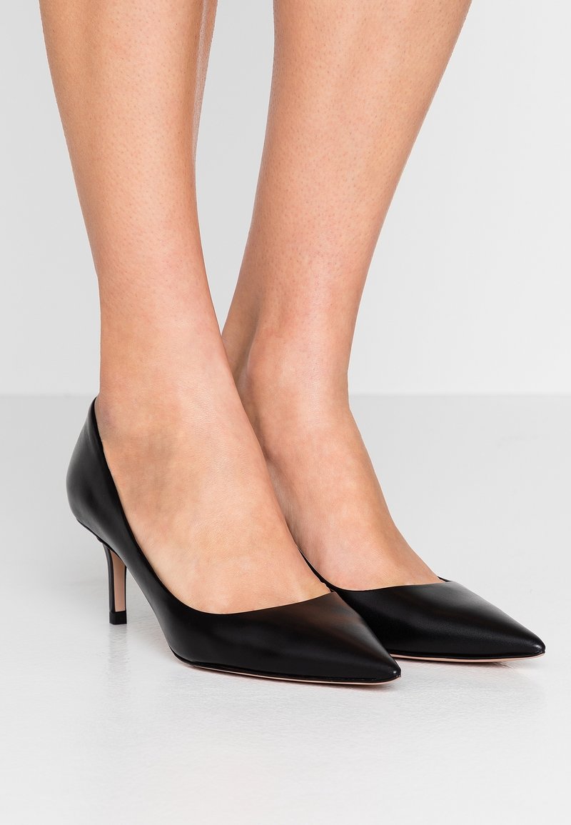 Décolleté in pelle nera con punta affusolata e tacco a stiletto di 5 cm. Texture liscia e design minimalista. Adatti per occasioni formali.