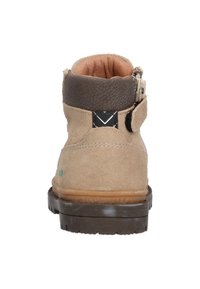 Stivaletto in suede beige con un colletto in pelle lavorata marrone, un accento nero e una suola in gomma. Presenta una chiusura con zip per facilitare l'indossamento.