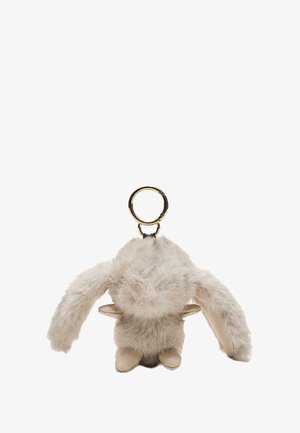 Zapestni obesek iz umetnega krzna v svetlo bež barvi, ki ima dolge ušesa, okroglo zlatobranico in mehak teksturiran mladostel, zaobljeno telo in majhne noge.