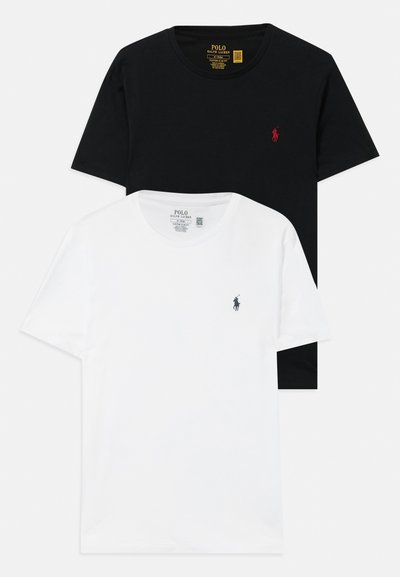 Δύο μπλούζες με στρογγυλή λαιμόκοψη: μία μαύρη και μία λευκή, και οι δύο από βαμβάκι, διαθέτουν μικρά κεντημένα λογότυπα στο στήθος σε αντίθετες αποχρώσεις.