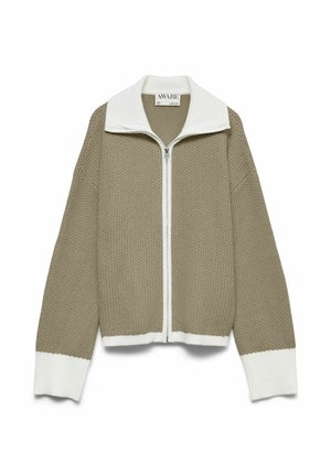 Pull beige en tricot gaufré avec fermeture éclair, col, poignets et ourlet blancs, manches longues et col montant.