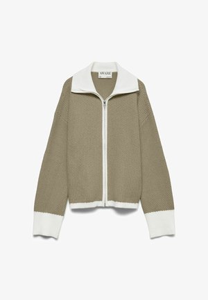 Pull beige en tricot gaufré avec fermeture éclair, col, poignets et ourlet blancs, manches longues et col montant.