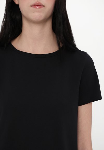 Sort kortærmet T-shirt med rund hals. Fremstillet af glat stof, tætsiddende ved skuldrene og afslappet omkring kroppen.