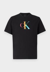 Juoda medvilninė marškinėliai su spalvingu "CK" logotipu priekyje. Klasikinis apvalus kaklas ir trumpi rankoviai, su lygia tekstūra.