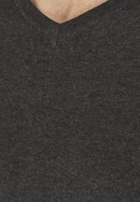 Mörkgrå v-ringad tröja i ett mjukt, texturerat stickat tyg. Halsringningen har en slät finish och det övergripande tyget ser lätt melerat ut.