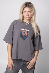 Šedé oversized tričko s grafickým potiskem kočičí tváře se sežehnutými modro-oranžovými plameny. Krátké rukávy, kulatý výstřih a měkká bavlněná textura.