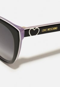 Black and purple sunglasses with a square shape. Features silver heart detail on the frame and "LOVE MOSCHINO" text in gold.Gradient lenses.