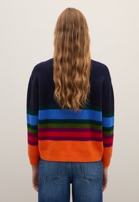 Knitted sweater featuring bold horizontal stripes in navy, green, blue, red, and orange, with a relaxed fit and ribbed cuffs.