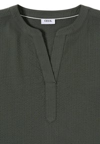Dunkelolivgrünes strukturiertes Hemd mit geteiltem Ausschnitt und genähter Knopfleiste, innen im Kragen mit "CECIL" beschriftet.