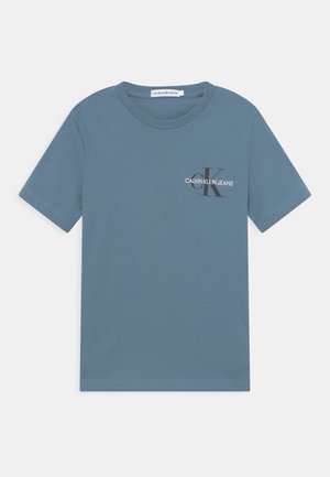 Niebieski t-shirt Calvin Klein Jeans z krótkim rękawem, okrągłym dekoltem i małym logo "CK" na lewej piersi.