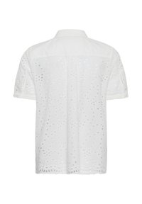 Chemise blanche à manches courtes en tissu ajouré avec motifs circulaires et floraux, vue de dos.