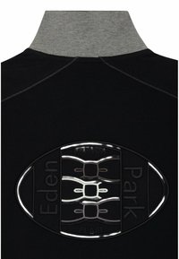 T-shirt polo noir avec un col gris haut. Présente un logo ovale texturé avec les détails "Eden Park" et "French Flair".